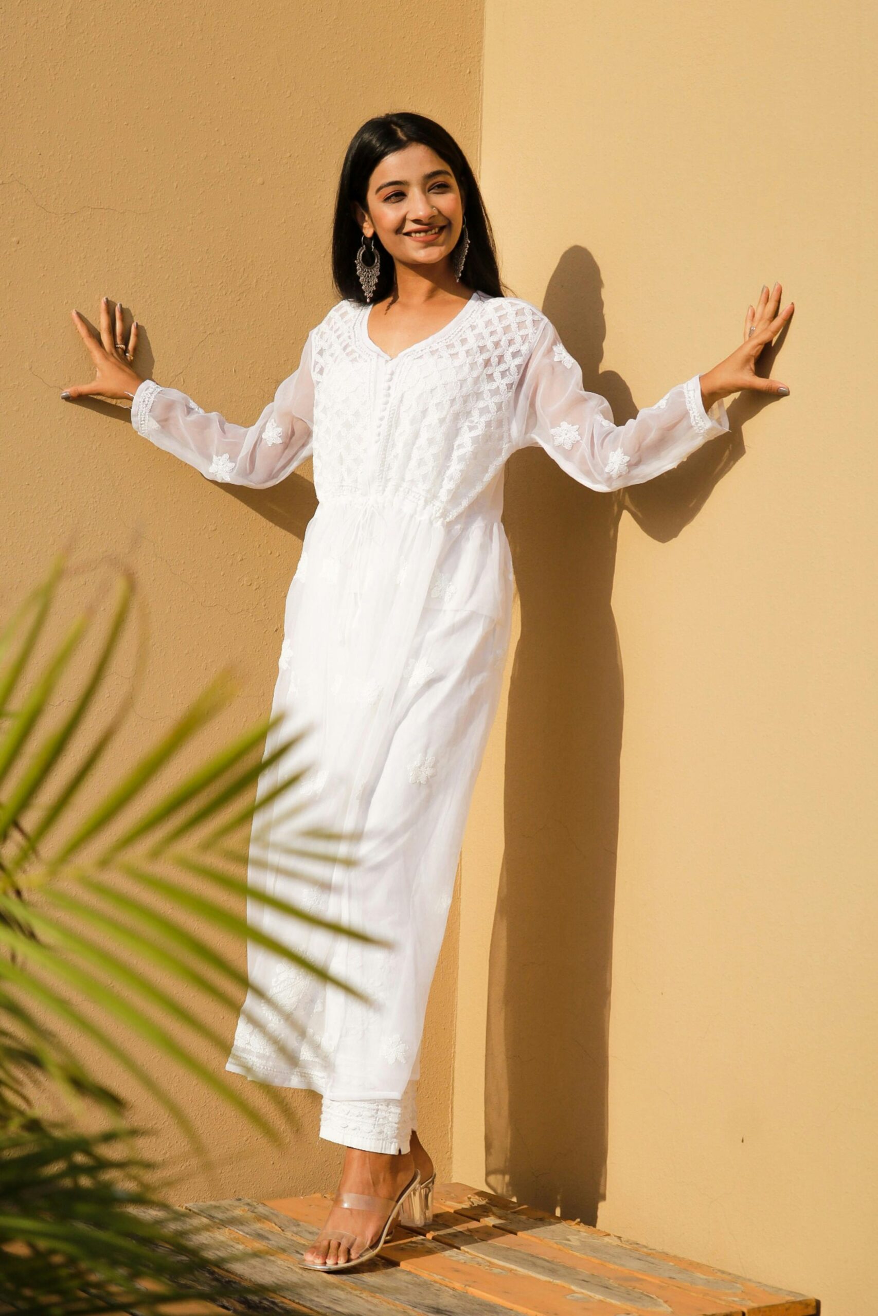 HOME Stylish woman in a white chikankari kurti outdoors, showcasing ethnic elegance.